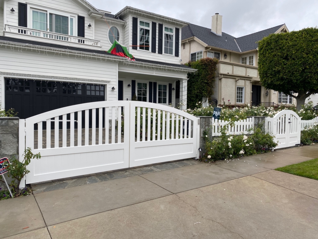 White arched solid driveway gates and fence