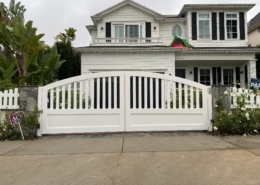 White arched solid driveway gates and fence