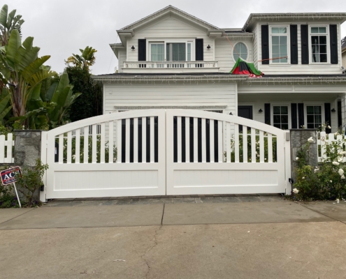 White arched solid driveway gates and fence